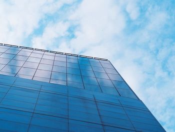 Low angle view of glass building against sky