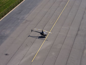 Aerial view of robinson r22 helicopter standing in middle of empty airport runway