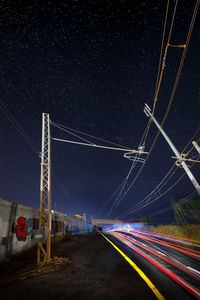 Light trails on road against sky at night