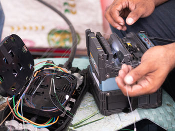 Midsection of man repairing machine