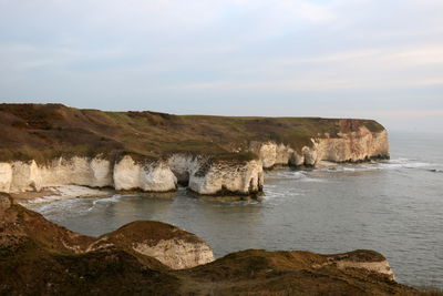 Scenic view of rocks on beach against sky