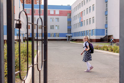 Back to school. girl in school uniform go to school with backpack behind their backs. beginning 