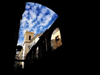 Low angle view of silhouette buildings against sky