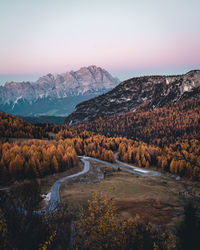 Road by mountains against sky during sunset