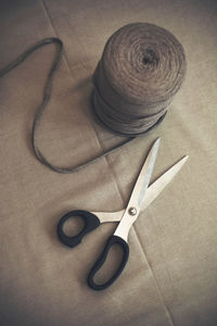 High angle view of wool spool and scissors on table