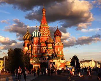 People walking on street outside st basils cathedral during sunset in city