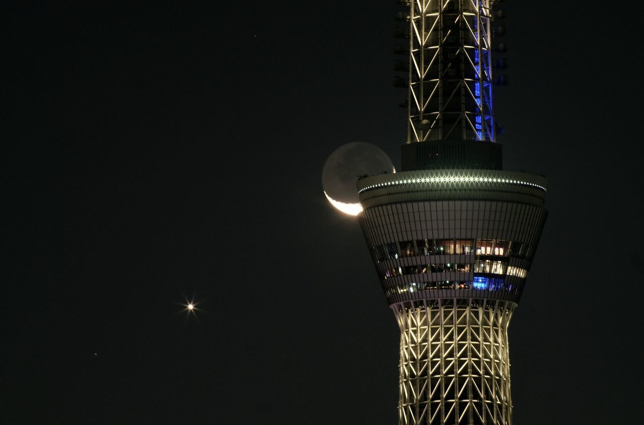 LOW ANGLE VIEW OF ILLUMINATED TOWER AGAINST SKY