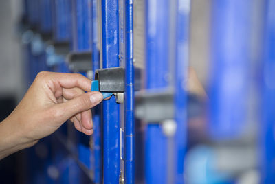 Cropped hand of person holding key in locker