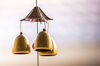 Close-up of bell hanging against sky