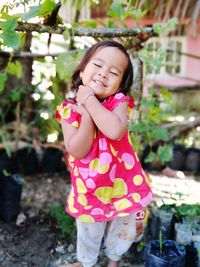 Little girl is enjoying the morning air by playing in the garden in front of the house
