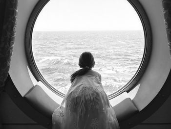 Rear view of girl looking at sea from tourboat