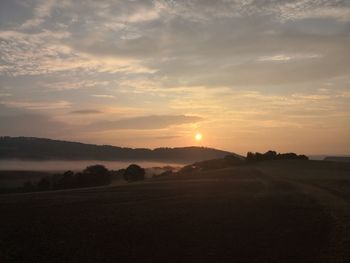 Scenic view of field against sky during sunset