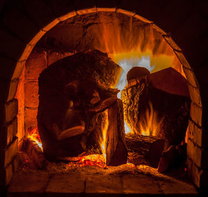 Close-up of fire on log at night