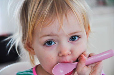 Close-up portrait of cute girl holding spoon