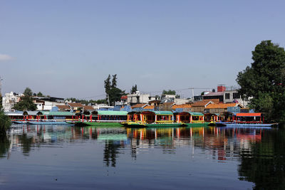 Buildings by river against sky