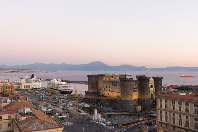 High angle view of buildings by sea against clear sky