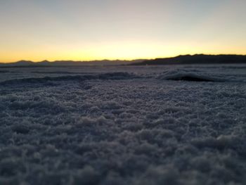 Close-up of sea against sunset sky