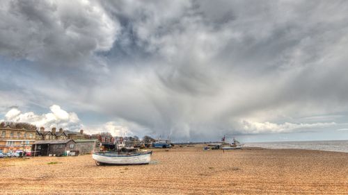 Boats moored on beach against sky
