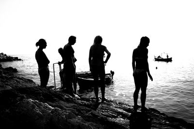 Silhouette people on beach against sky