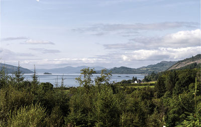 Scenic view of trees and mountains against sky