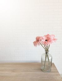 Flower vase on table against wall
