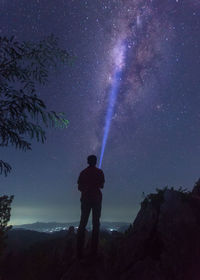 A man standing under a sunny milkyway during a clear night sky