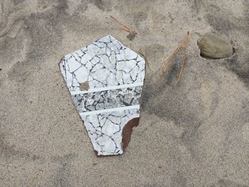 High angle view of broken paper on rock