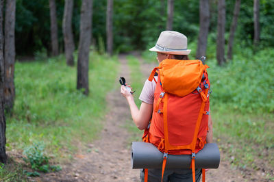 Rear view of woman standing in forest