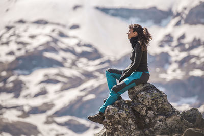 Hiker sitting on rock at sunny day