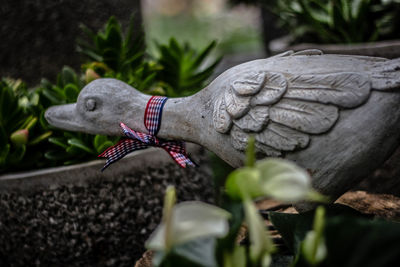 Close-up of hand statue against plants