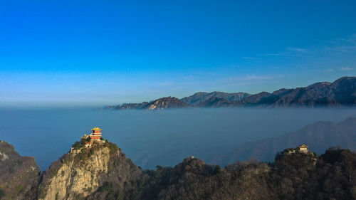 Panoramic view of buildings on mountain against blue sky