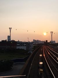 Railroad tracks against sky at dusk