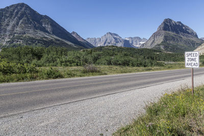 Road by mountains against sky