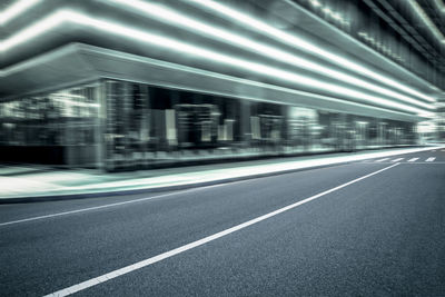 Blurred motion of empty road against buildings in city