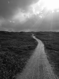 Empty road on field against sky