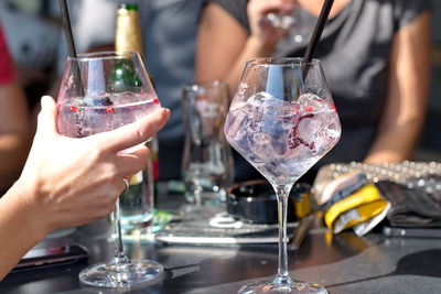 Close-up of hand holding wine glass on table