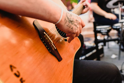 Midsection of man playing guitar