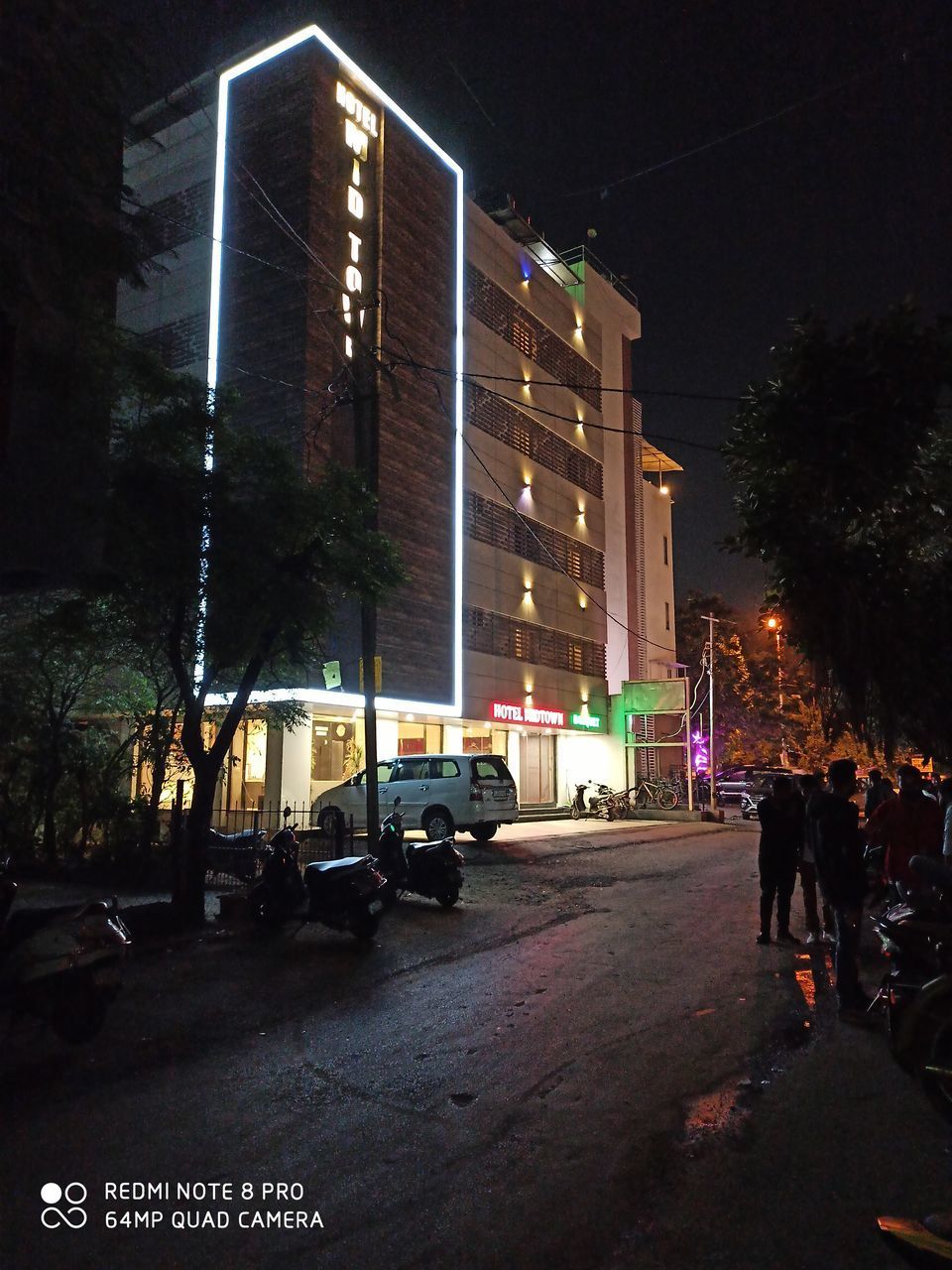 REAR VIEW OF VEHICLES ON ILLUMINATED STREET AT NIGHT