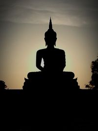 Low angle view of silhouette statue against sky during sunset