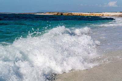 Waves splashing on sea against sky