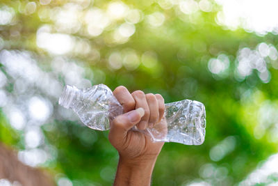 Close-up of hand holding ice over water