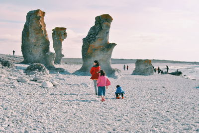 Tourists on rock formation at seaside