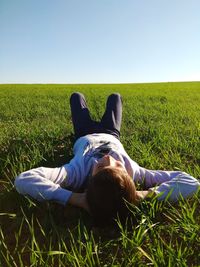 Rear view of man lying on grass