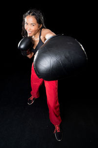 Young woman wearing hat against black background