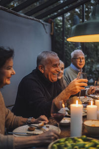 Happy mature man enjoying with retired friends during dinner party