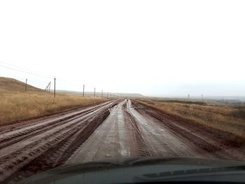 Road against clear sky seen through car windshield