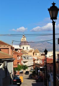 Street amidst buildings against sky in city