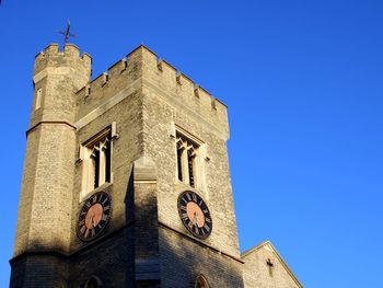 Low angle view of clock tower against clear blue sky