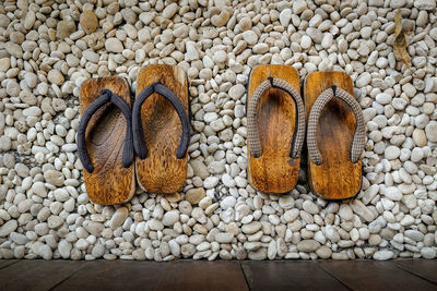 High angle view of wooden footwear on pebbles