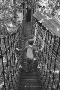Rear view of woman walking on footbridge